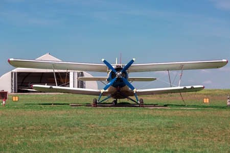 The old plane, agricultural aeroplane costs in the field in a green grass.の写真素材