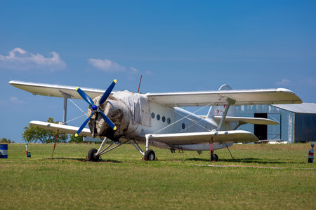 The old plane, agricultural aeroplane costs in the field in a green grass.