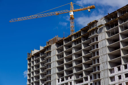 High rise building under construction, seen from below against blue sky