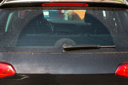 dirty rear glass of the car of black color, back view.の写真素材
