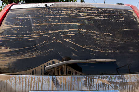 Dusty rear screen of the car, the dirty car the rear view on tinted glass.の写真素材