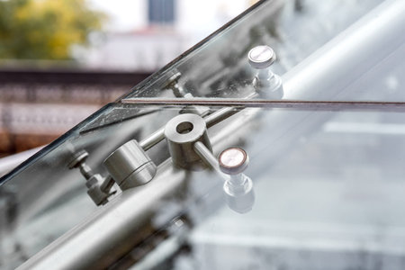 Connecting fasteners for glass structures close-up, view through the glass from the outside.