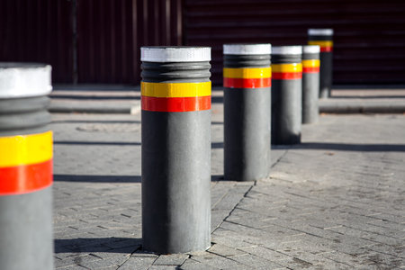 bollards with reflective stripes enclose the passage of transport to the pedestrian zone with gray...