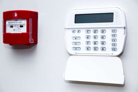 alarm control panel and fire button on a light gray wall, close-up of the security password entry system to activate and set the alarm.の写真素材