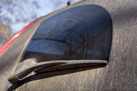 Close up of a dirty car wiper on a dirty back window in mud and divorce.
