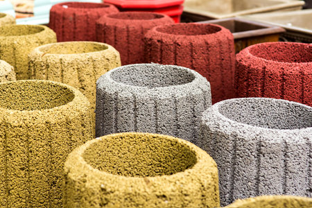 stone trash can in an assortment of new multi-colored garbage cans closeup.の写真素材