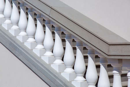 White balustrades with handrails of gray stone stairs, close up of details of stairs by the sunny day.の写真素材