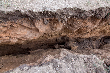 a landslide with cracks in the soil, a closeup of the crack inside the clay gorge.