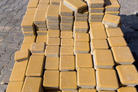 repair yellow paving slabs piled in a pile one on top of another on a sunny day, close up.