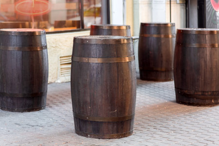 brown wooden wine barrel on the street on stone paving slabs, bar restaurant decorations close up...