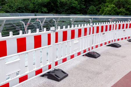 striped barrier warning fencing of a dangerous place on a glass bridge, nobody.