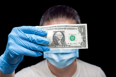 1 dollar bill in hands in medical gloves holds a man in a sick mask, a concept on the medical theme...