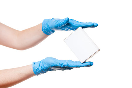 Delivery hands in blue sterile latex gloves holds white label cardboard box, safe delivery during...