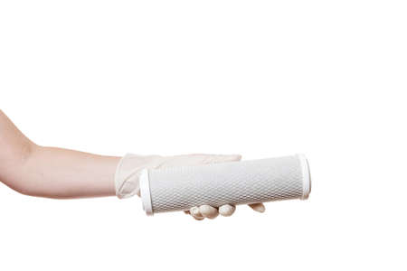 reticulate cartridge filter for drinking water purification carbon mesh demonstrate holding in hand in sterile glove isolated on a white background with a copy space.の写真素材