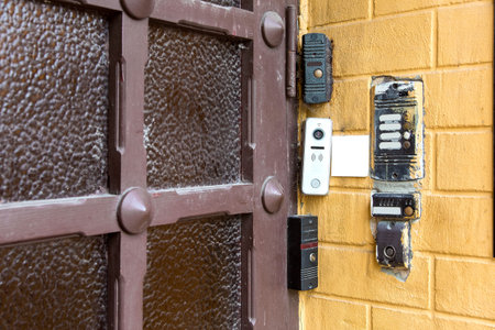 several types of different intercoms and electronic locks on a chip or card on a yellow brick wall...