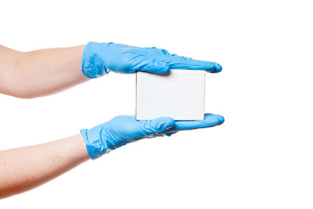 Delivery hands in blue sterile latex gloves holds white un label cardboard box, safe delivery during quarantine of coronavirus covid-19 stay home, concept isolated on white background with copy space.の写真素材