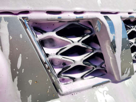 dirty car radiator grill covered with foam for washing and cleaning from dirt and insects, nobody auto close-up details.の写真素材