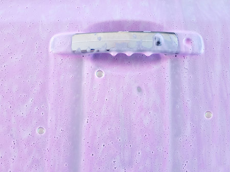 car driver door chrome handle covered with active foam for washing a dirty car and pink wax, closeup...