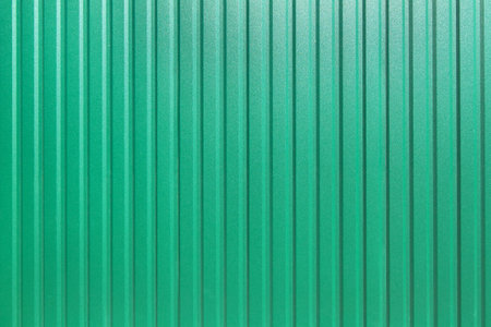 galvanized iron fence with corrugated vertical stripes closeup of the texture of the top coat of a...