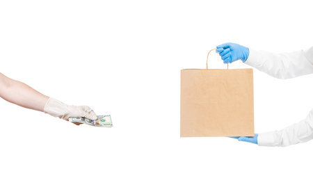faceless delivery man hold in hands brown craft paper package and hand holds give money to pay for...