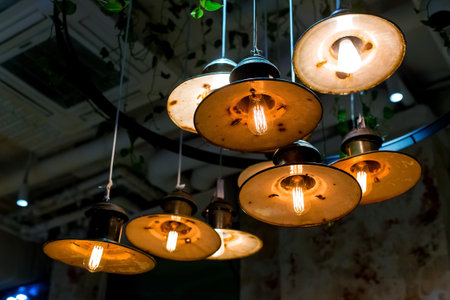 several round pendant retro loft style lanterns with edison bulbs shine with warm light in the...