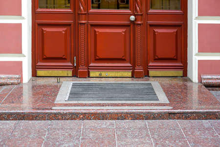 wooden composite door with glass building entrance with threshold and foot mat close-up of retro european style architecture, nobody.の写真素材