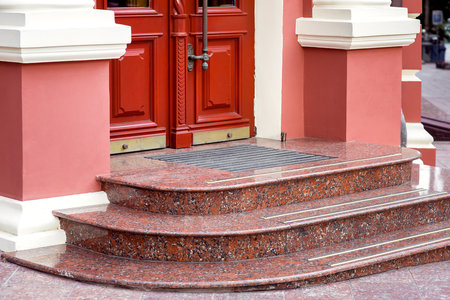 entrance double door with threshold with marble steps and foot mat closeup of European retro style architecture facade side view, nobody.の写真素材