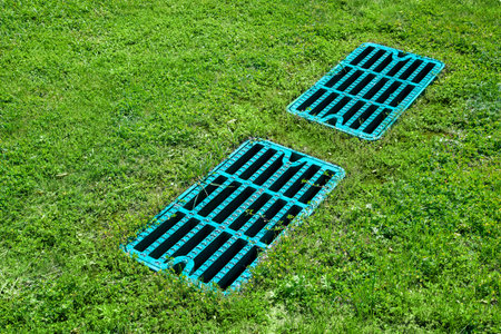 manhole drainage grates on the lawn with green grass septic tank cover, sump cesspool drainage...
