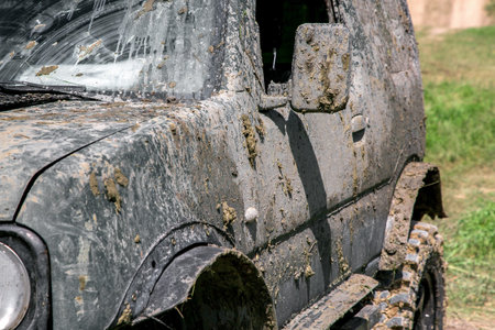 a muddy car in a swamp layer after an off-road trip, a close-up of a side driver door with rear view...