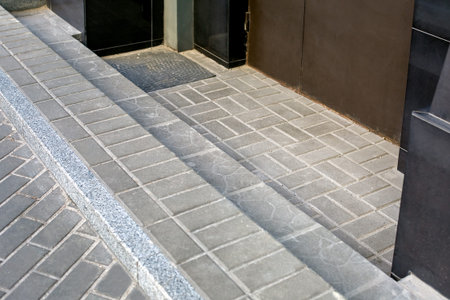 brown iron entrance door to the building with granite curb and stone tile step close-up of the...