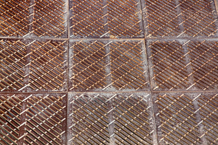 old rusty square shaped drainage grate, the surface of the storm system on the floor close-up.