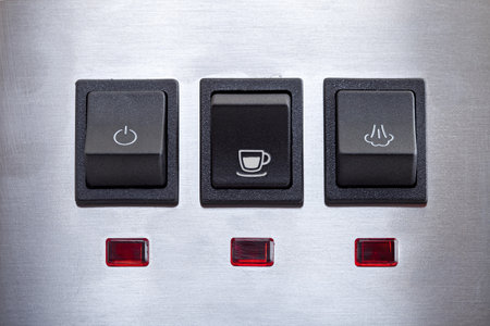 Black coffee brew button with drink cup symbol, close-up of panel with black plastic buttons for espresso coffee machine and heat steam for milk frothing.の写真素材