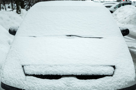 parked car in city parking blocked by snowfall, windshield with windshield wipers covered with snow, blocked lost car in snowy winter morning, nobody.の写真素材