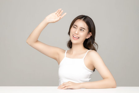 Young Sad Asian woman holding credit card with blank screen mobile phone on gray background. Portrait of pretty girl in studio. cashless society Concept.の写真素材
