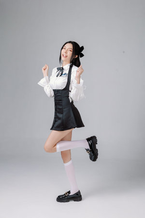 Full length Pretty teenage Asian High School woman model in student uniform has lovely face is with...