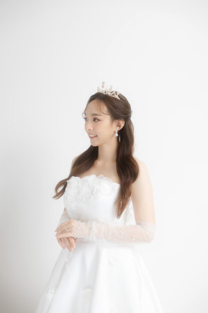 Beauty portrait of Asian beauty bride wearing luxury fashion wedding dress with diamond ring and trendy make-up on face Feeling so proud and happinessの写真素材