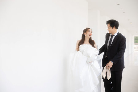 Lovely Asian couple in wedding attire walking together in a romantic luxury hotel. The groom asked the bride to marry.の写真素材