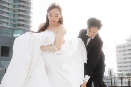 Lovely Asian couple in wedding attire walking together in a romantic luxury hotel. The groom asked the bride to marry.の写真素材