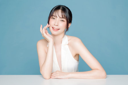 Young Asian beauty woman bangs hair with makeup lovely style on face and perfect clean skin care on isolated blue background. Facial treatment, Cosmetology, plastic surgery.の写真素材