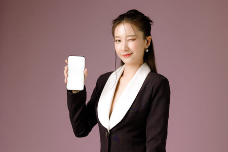 Fashionable Asian business woman have good figure and clear fresh skin in black trendy dress holding...