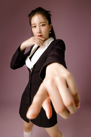 Fashionable Asian business woman have good figure and clear fresh skin in black trendy dress pose on isolated pink background. Body and skin care, health, spa, cosmetics.の写真素材