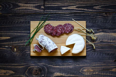 Italian bruschetta made with toasted slices of bread with olives, cherry tomatoes and  olive on a  Board over dark wooden backgroundの写真素材