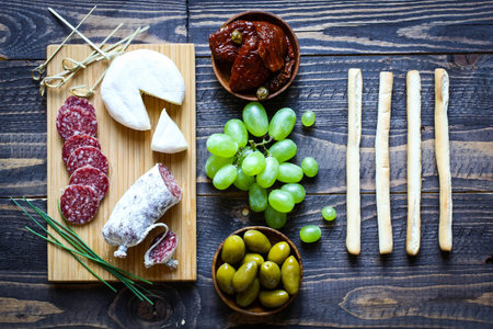 Italian bruschetta made with toasted slices of bread with olives, cherry tomatoes and  olive on a  Board over dark wooden backgroundの写真素材