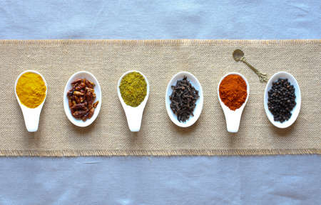 Spices in the spoons over a black stone tableの写真素材