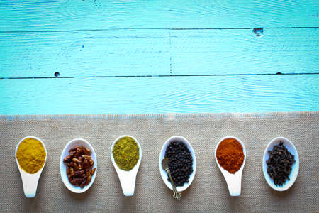 Spices in the spoons over a black stone tableの写真素材
