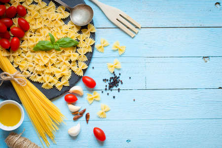 Italian pasta with pesto sauce made with basil leafs, pine nuts, fresh garlic and olive oil over an old wood background, top viewの写真素材