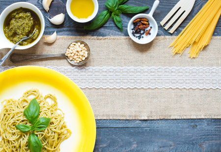 Italian pasta with pesto sauce made with basil leafs, pine nuts, fresh garlic and olive oil over an...