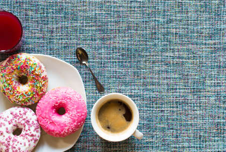Morning breakfast with colorful Donuts and expresso coffee on a rustic wooden background. Top viewの写真素材