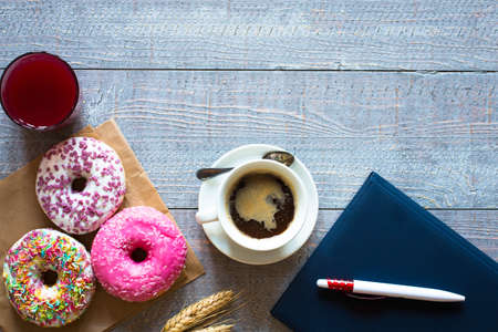 Morning breakfast with colorful Donuts and expresso coffee on a rustic wooden background. Top viewの写真素材