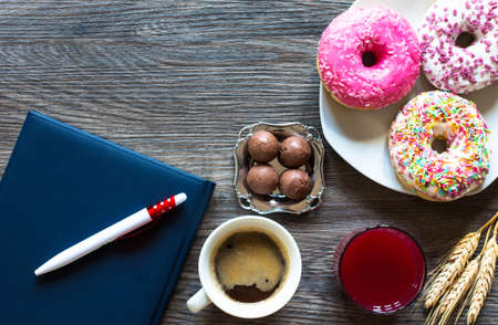 Morning breakfast with colorful Donuts and expresso coffee on a rustic wooden background. Top viewの写真素材
